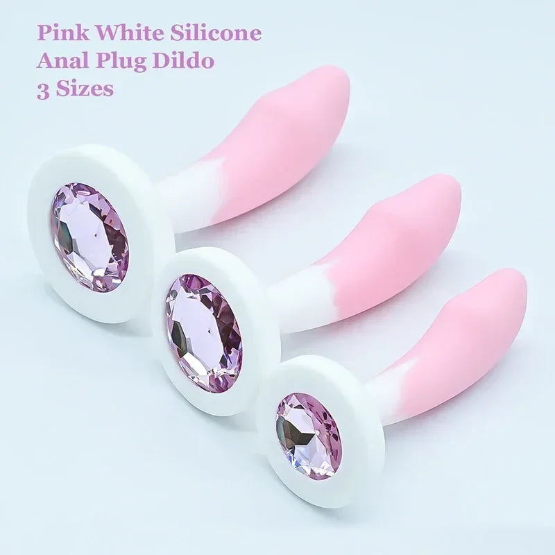 Pink and white silicone anal plug  with gemstones on a light gray background.