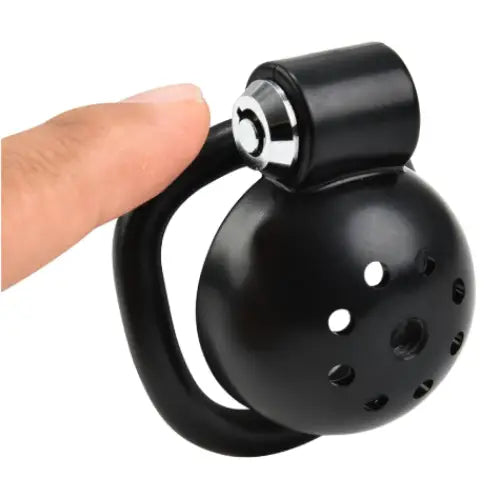 Black Chastity cage with a handle held by a hand on a white background