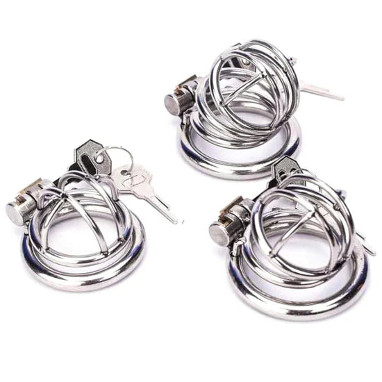 Set of metal chastity cages with rings, locks, and keys shown together