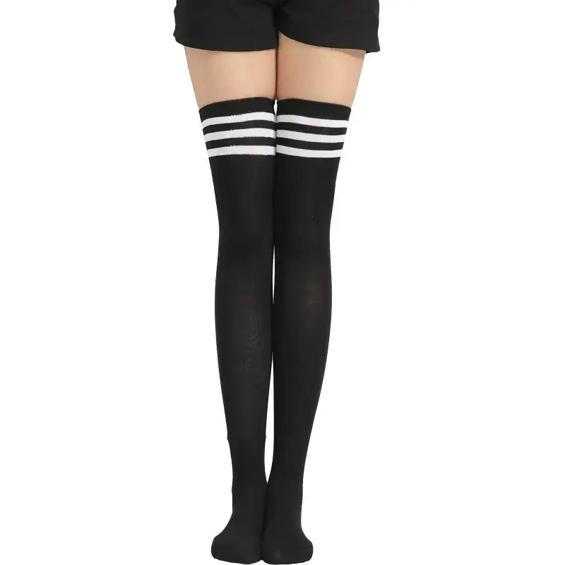 Black knee-high socks with white stripes worn by a person on a white background