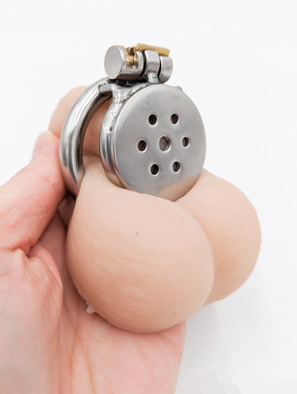 Flat metal chastity cage with secure lock and ventilation holes for comfort