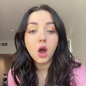 Person with text overlay 'CUTEST CAGE EVER!!!!' in a casual indoor setting