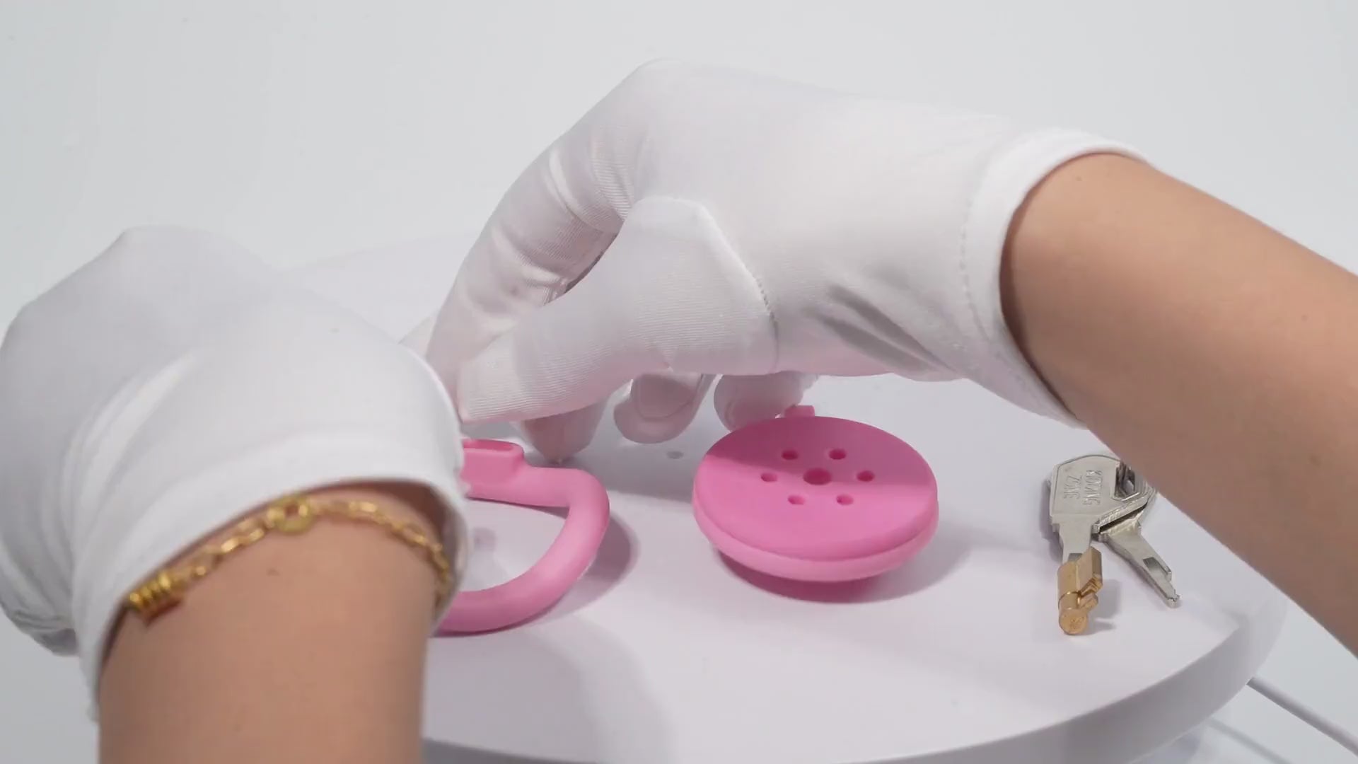 Pink flat chastity cage demonstration with rings, lock, and keys